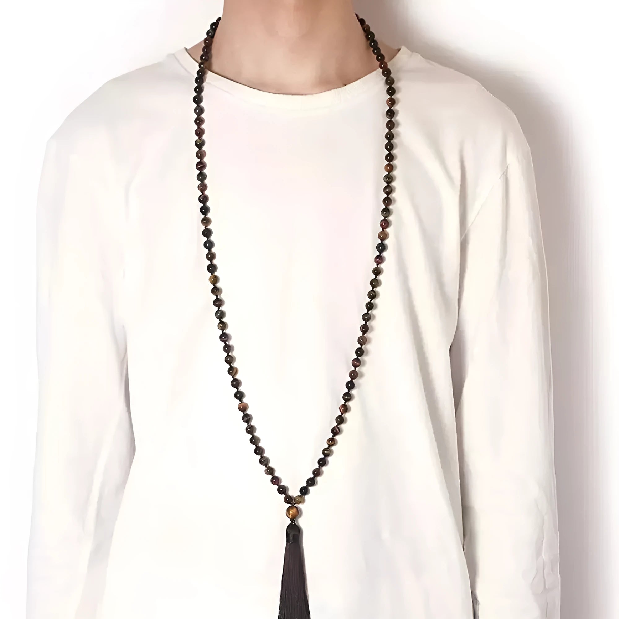 Long beaded agate and amethyst tassel necklace with geometric pendant on a neutral background.
