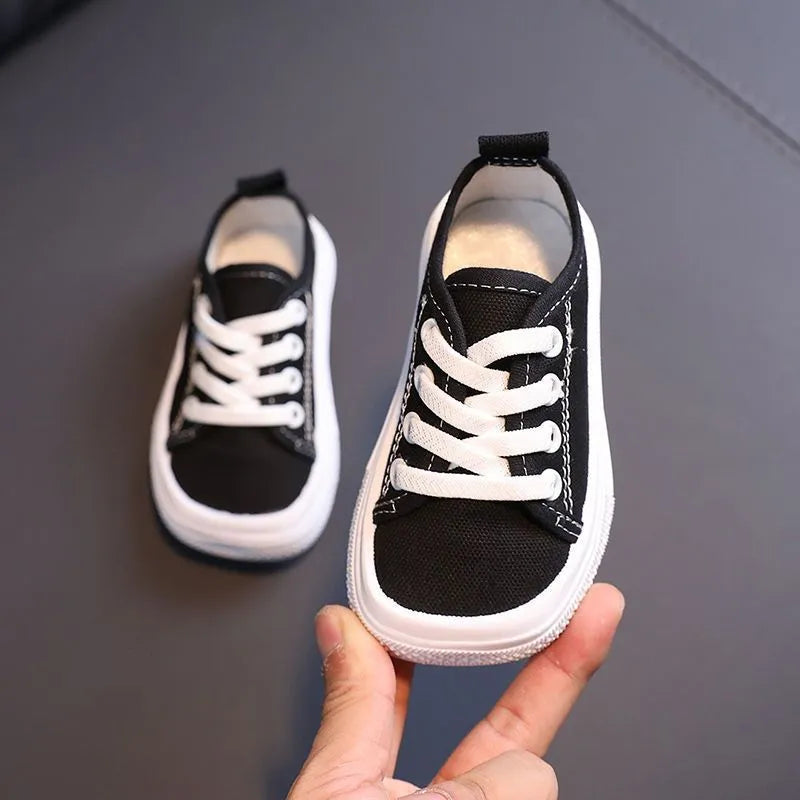 Children's canvas shoes low top sneakers in orange black white leopard print and plaid on a white background