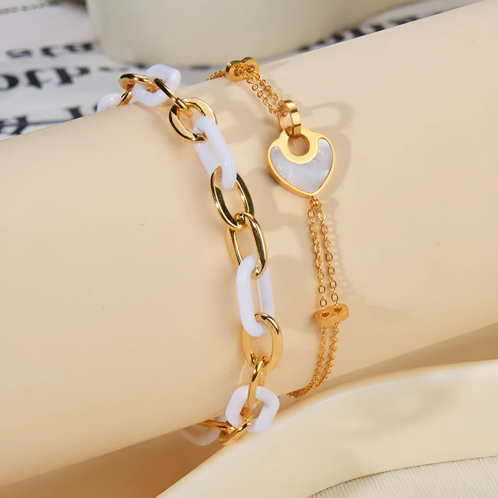 Silver stainless steel bracelet with a double-layer heart pendant featuring dark resin insets
