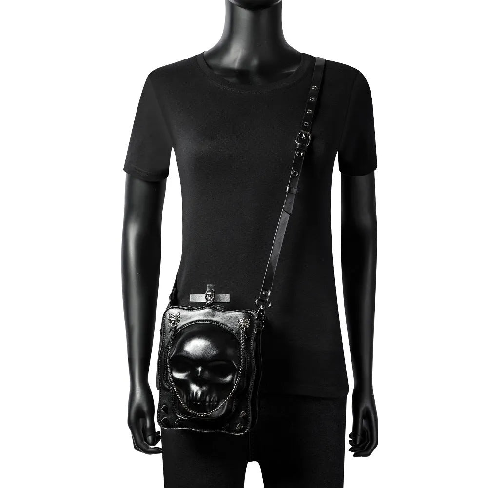 Black mini square crossbody bag with 3D embossed skull design, stitching, and chain detailing