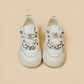 Casual women's white low-top sneakers with rubber sole and lace-up closure on a neutral background