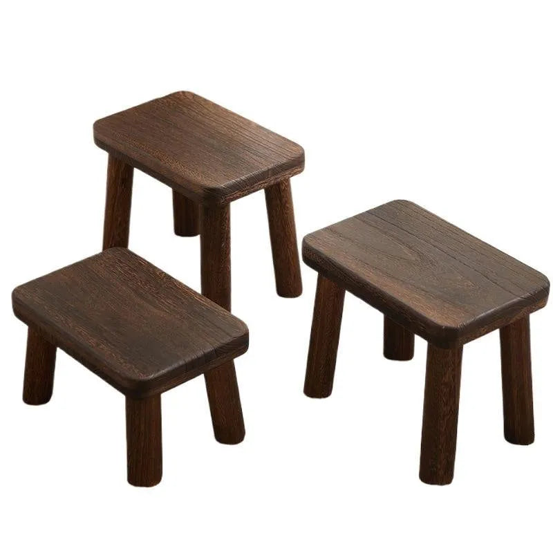 Distressed wooden shoe changing stool with bracket construction in living room setting