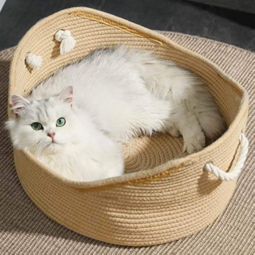 Wicker cat bed basket with a corrugated scratching board inside, shown in a home setting.