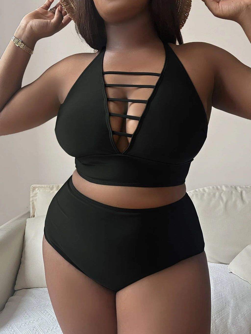 A plus size woman modelling a solid colour halter bikini with adjustable cross-back straps and high-waist briefs.