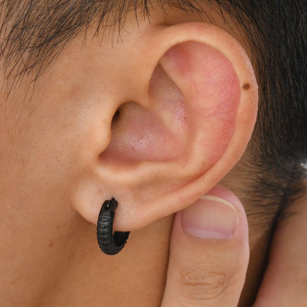 A pair of stainless steel earrings with a snake pattern design in a black finish.