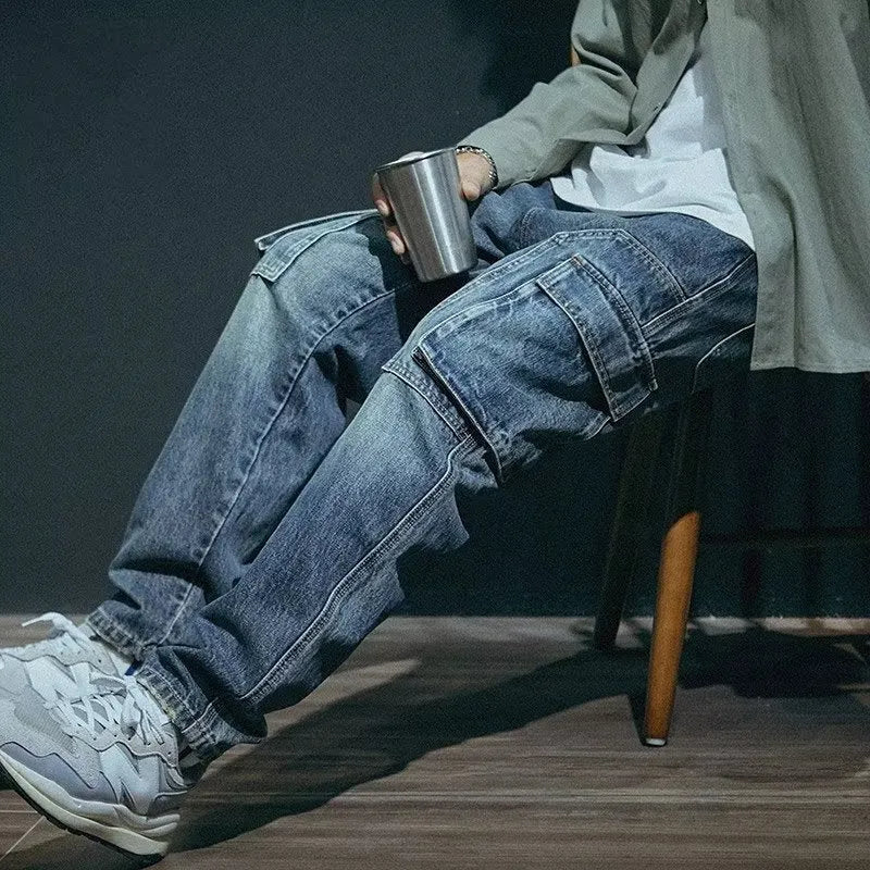 Men's blue loose straight-leg denim trousers with a zip fly placket laid flat.
