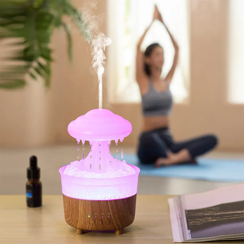 Wood grain white rain cloud shaped humidifier diffuser with coloured LED lights on a table