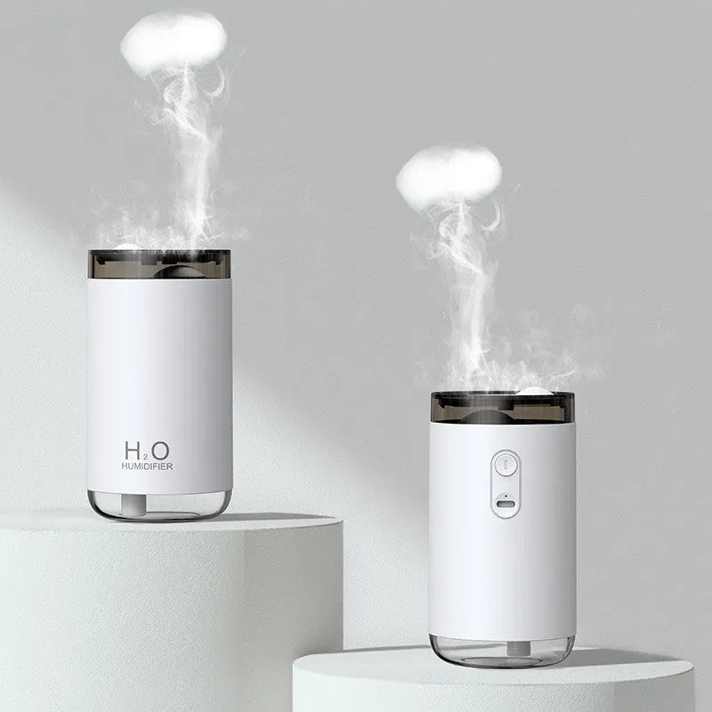 Blue jellyfish-shaped USB humidifier emitting smoke ring mist with warm night light on, placed on a wooden desk.