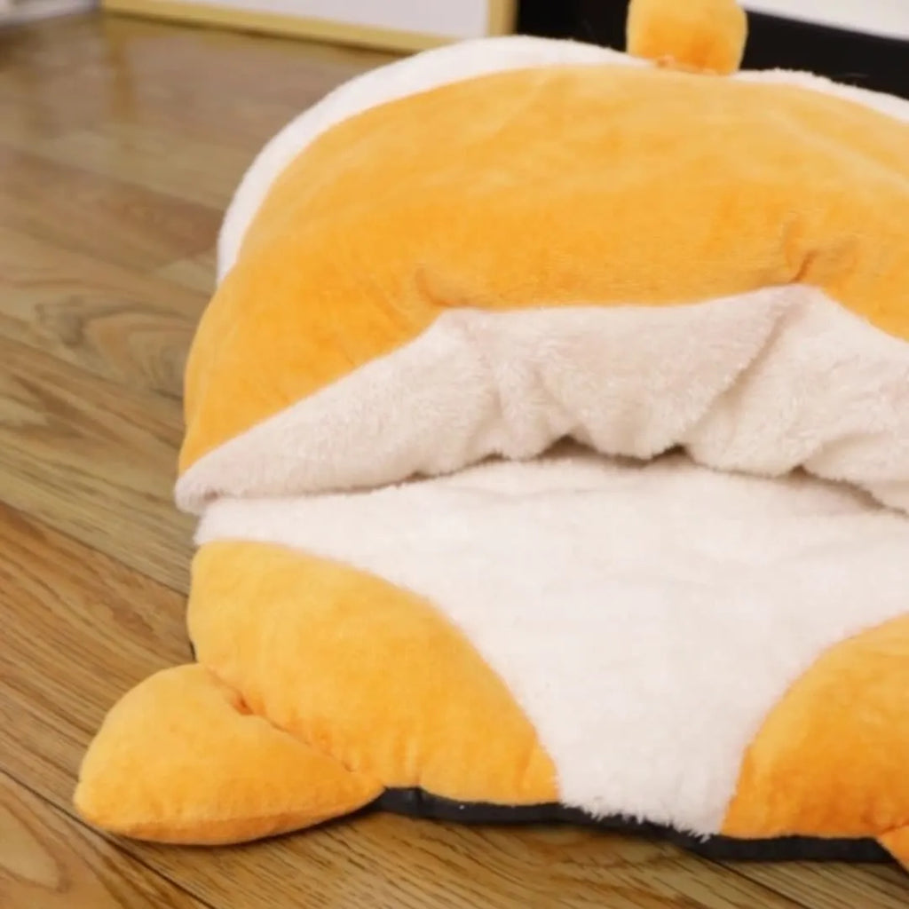 Orange semi-closed cat sleeping bag on a floor, showing its dimensions and sheltered design.