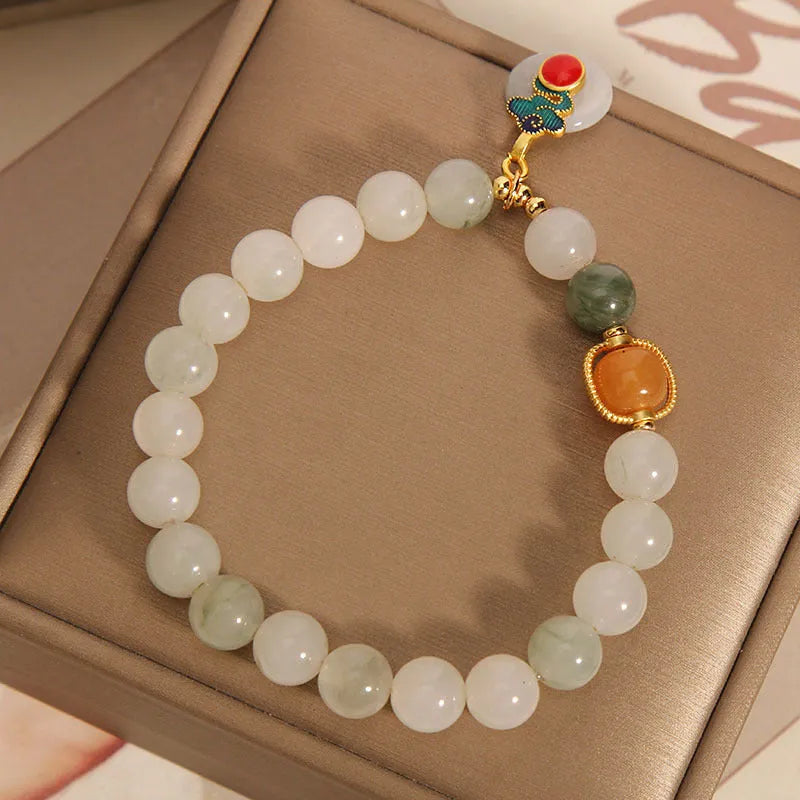 Women's ice jade crystal bracelet with Xiangyun peace buckle and pearl details.