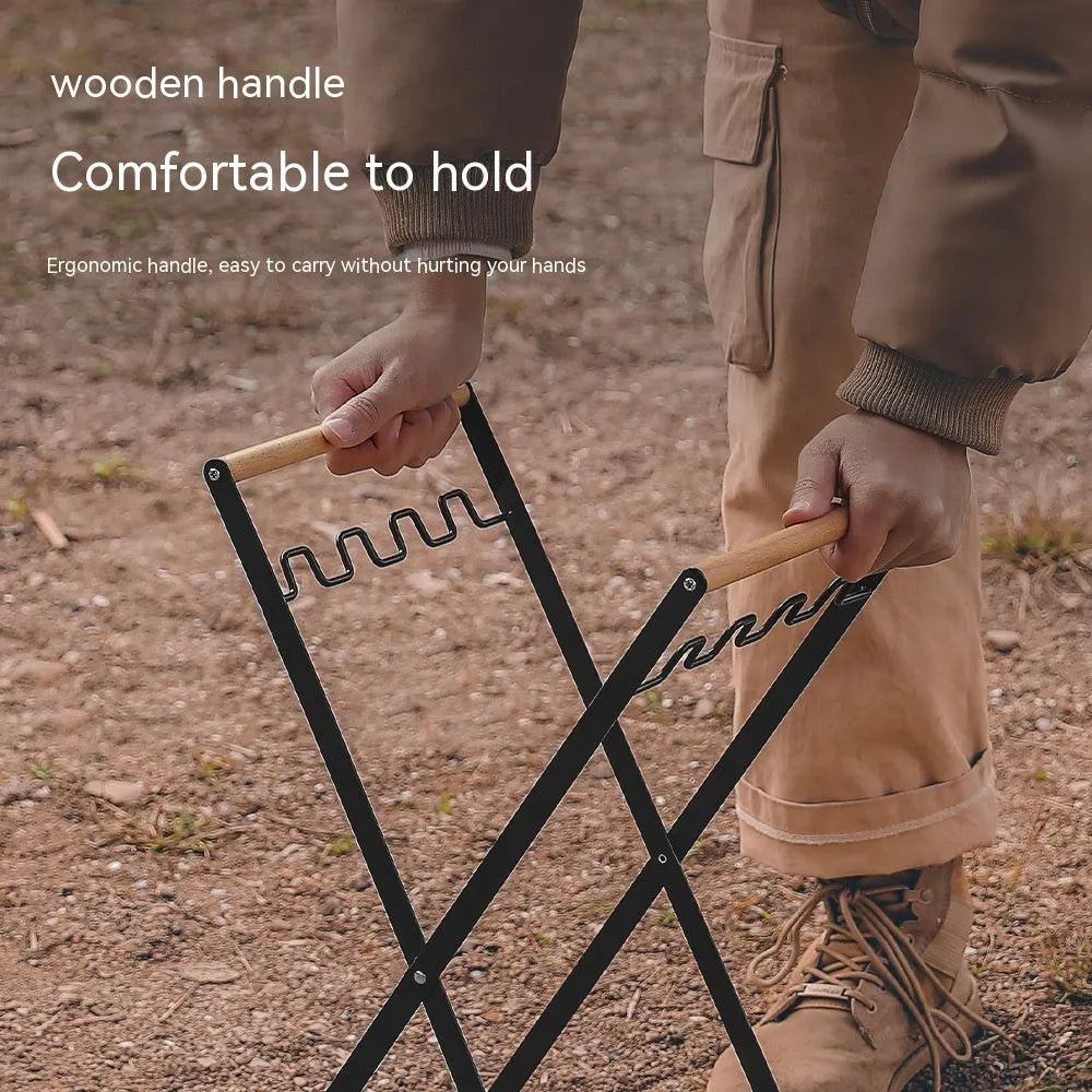 Foldable black wrought iron garbage storage hanger with a wooden handle, shown holding a bin bag.