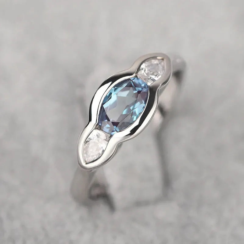Women's geometric ellipse ring with inlaid zircon stone in white gold colour, shown on a hand.