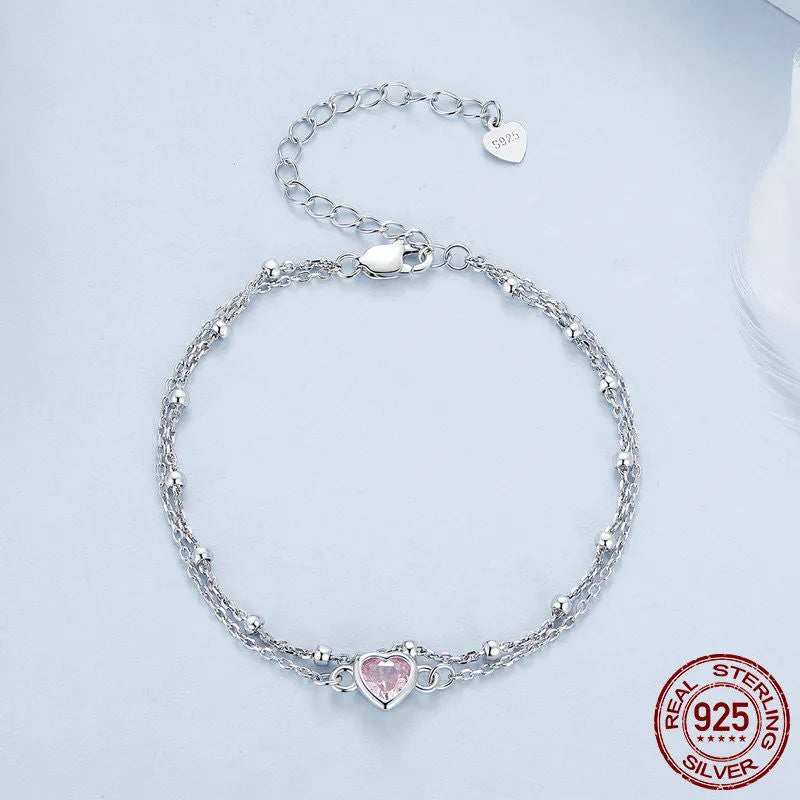 Women's sweet style sterling silver heart bracelet with adjustable chain on white background.
