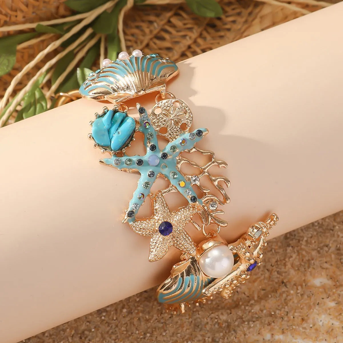 Alloy rhinestone bracelet with boat anchor and starfish charm in turquoise, red, or blue.