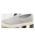 Men's beige canvas slip-on shoes with round toe and PVC sole on a plain background