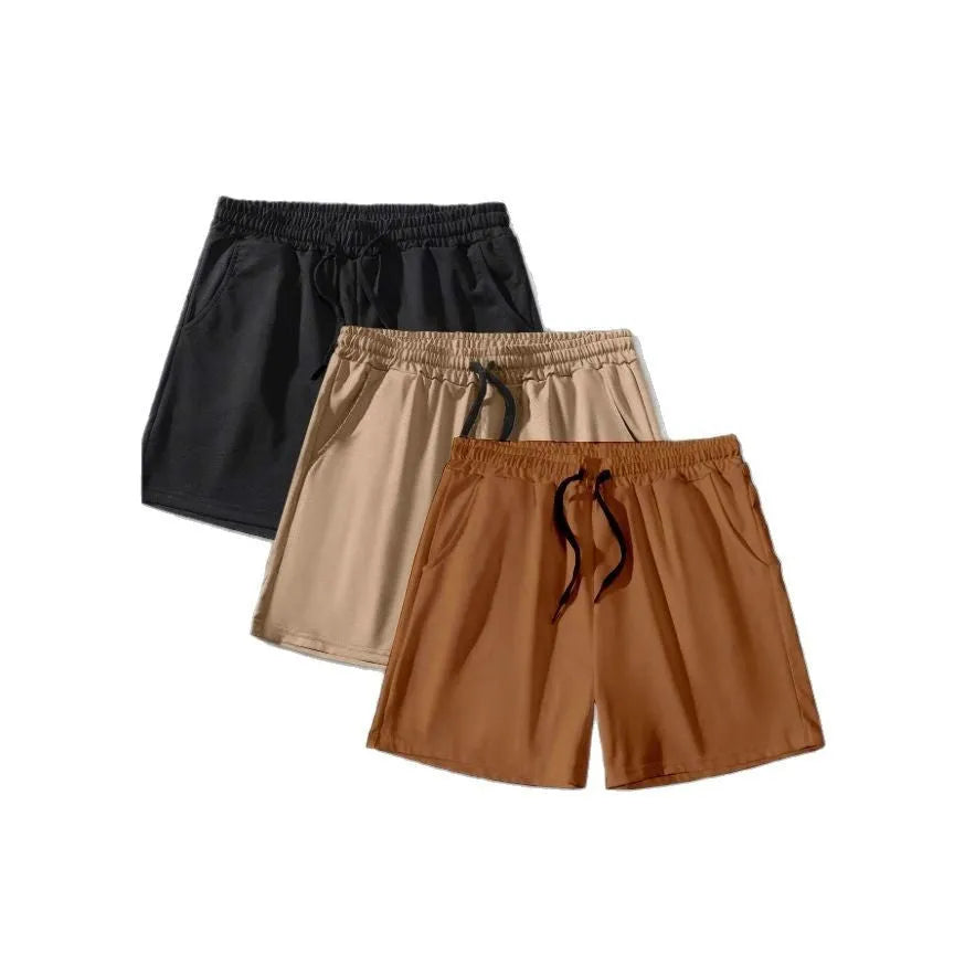 Three pairs of men's solid colour shorts in black, khaki, and light brown with drawstring waistbands
