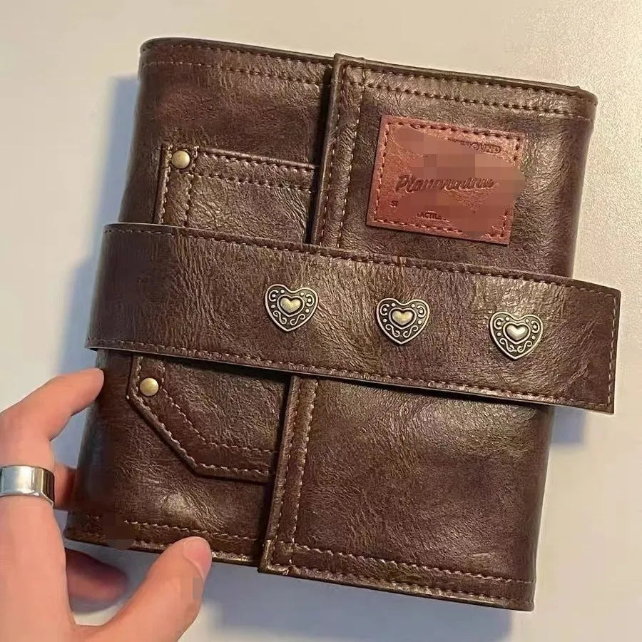 Brown A7 size notebook with a retro PU cover and leather buckle, showing loose-leaf binding.