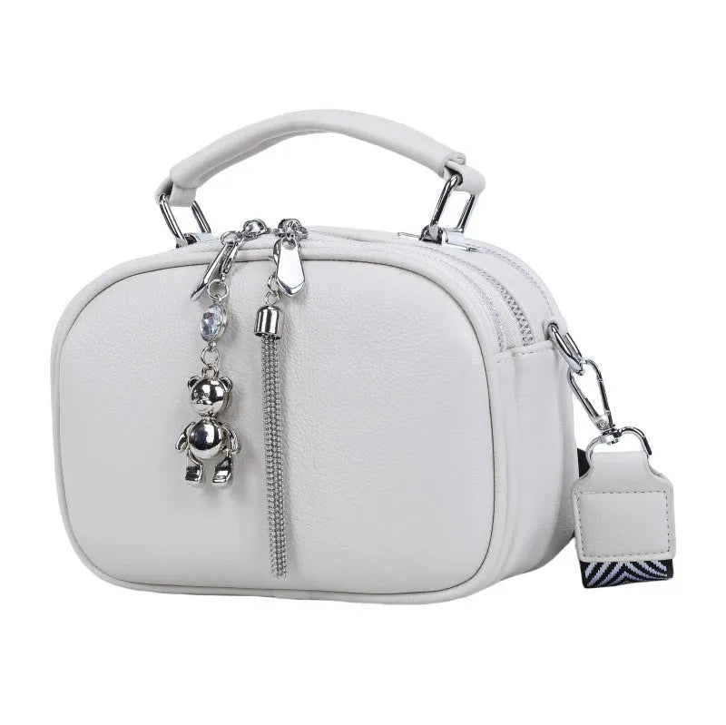 Women's small oval crossbody bag in PU with stitching detail and double straps, shown in multiple colours.