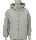 A woman wearing a loose-fitting grey hooded shell jacket with long sleeves, showing the front zip closure.