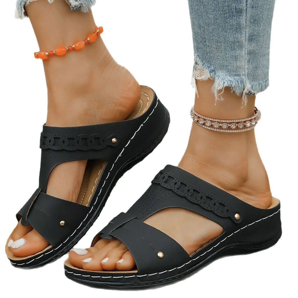 Pair of blue Roman-style slope heel slippers showing fish mouth toe holder design.