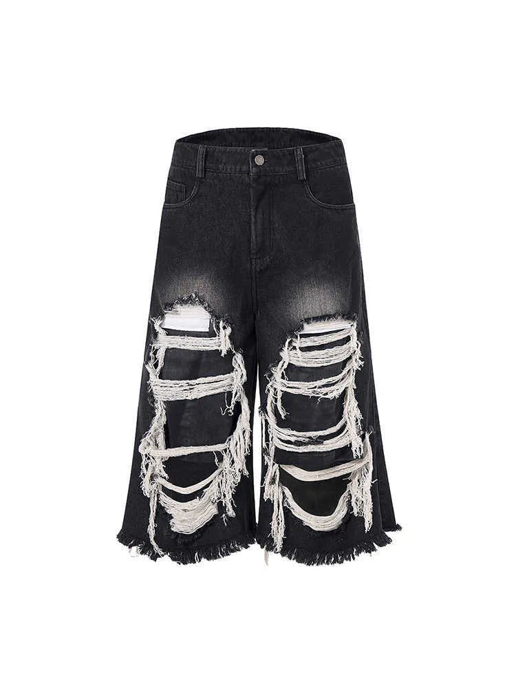 Black wide-leg cropped jeans with ripped patch details on a mid-high waist, loose fit.