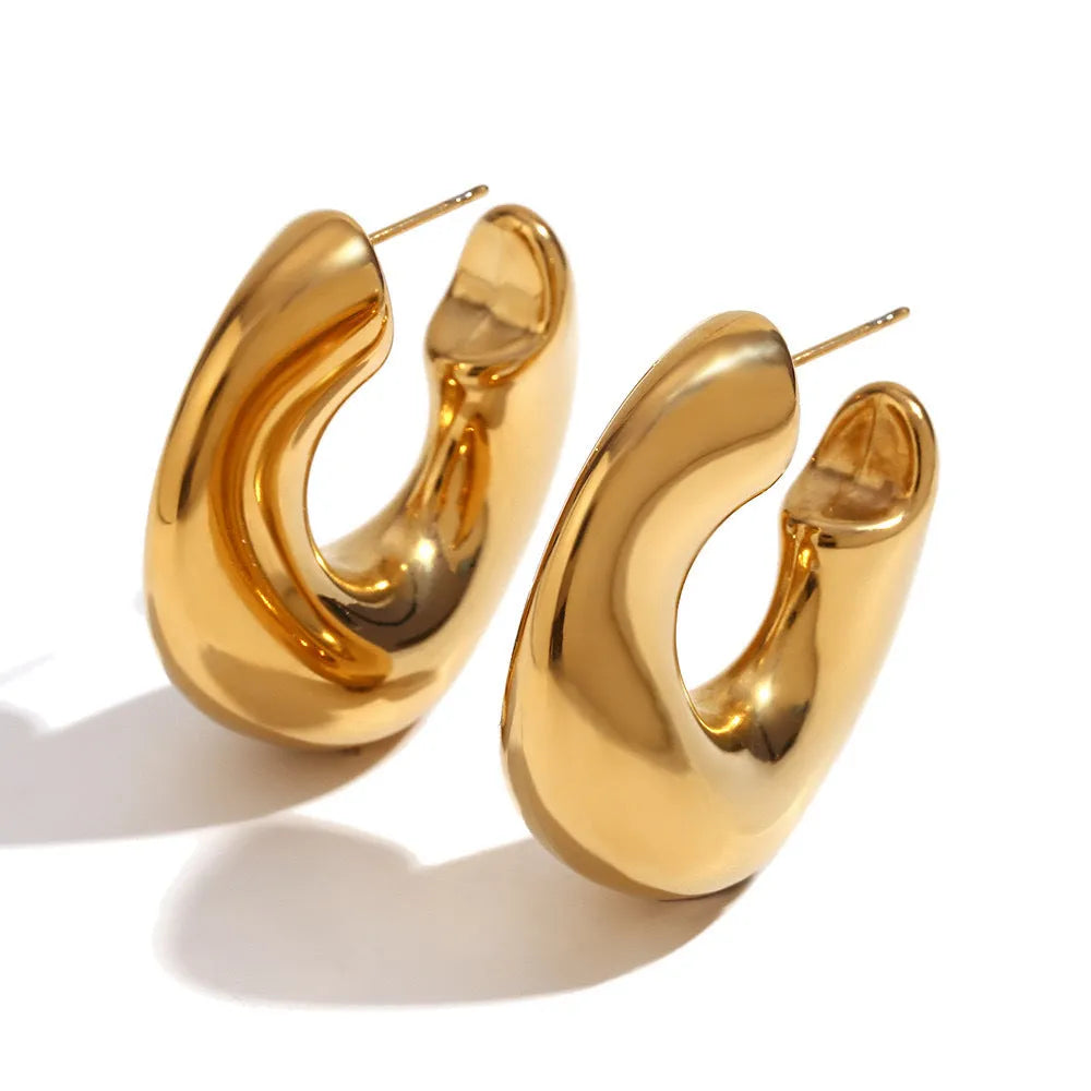 Gold and silver hollow irregular stainless steel earrings with geometric line design on white background
