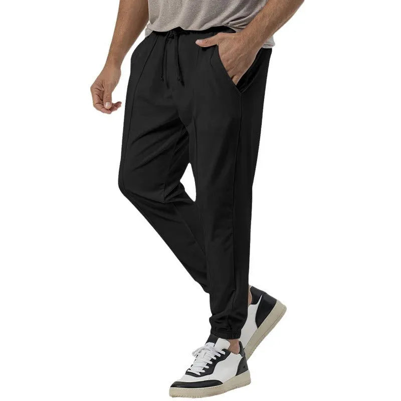 Men's grey elastic track sweatpants with tapered straight-leg design and elastic waistband