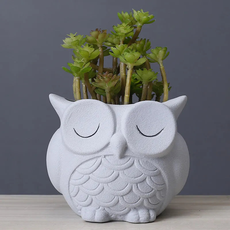 Handmade frosted ceramic flower pot with a cartoon owl design, shown in light pink.