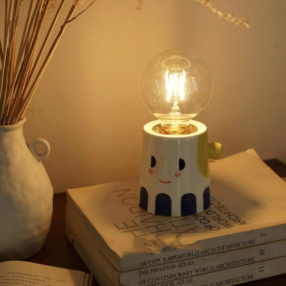 Handmade ceramic lamp with ball headlight design on wooden surface