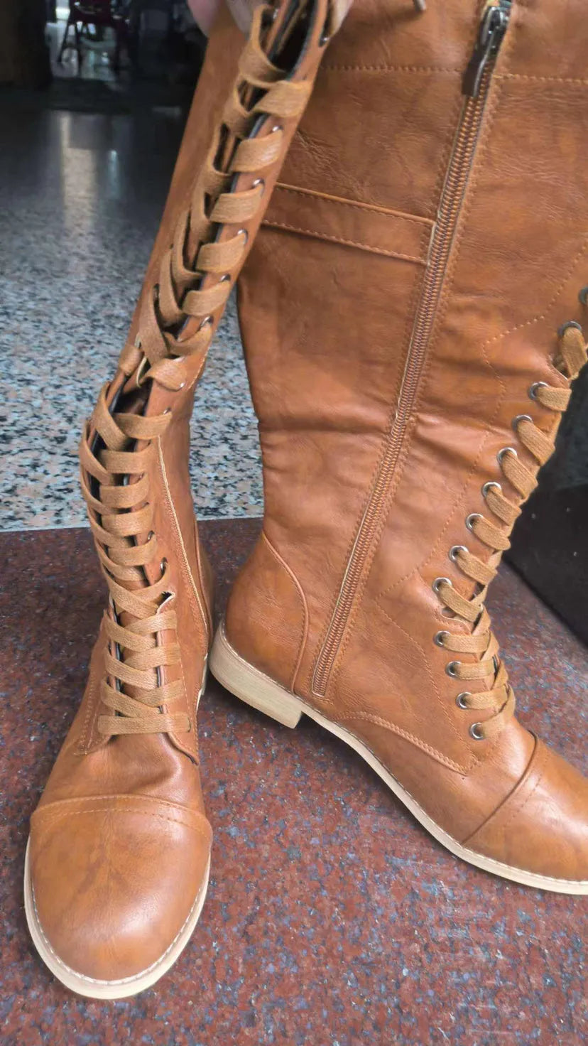 Women's black knight ankle boots with a cross strap over the instep, made from artificial PU.