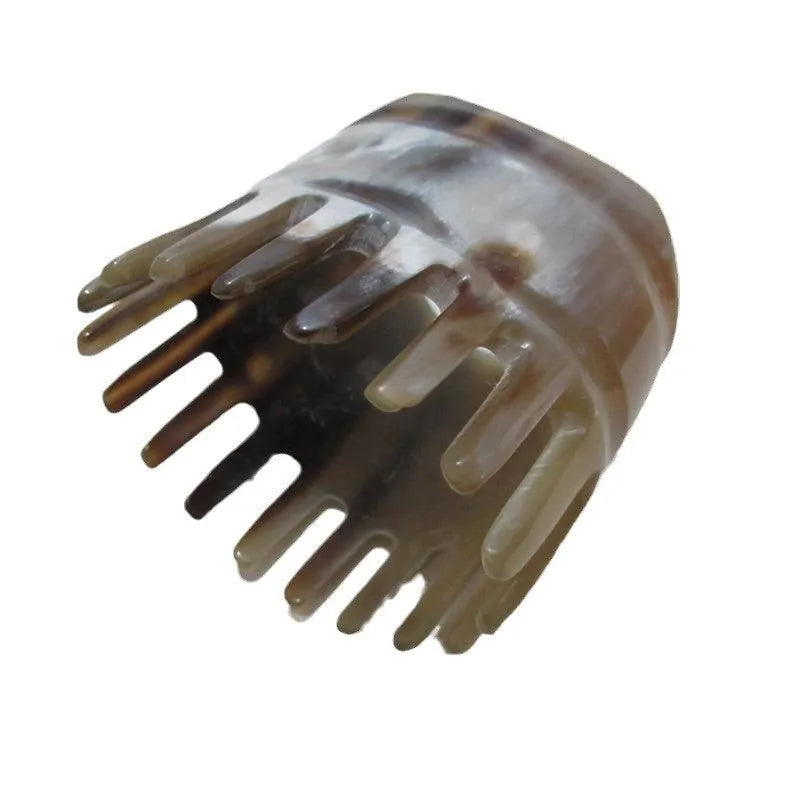 Black horn head massage comb with wide teeth and a pointed tip on a white background