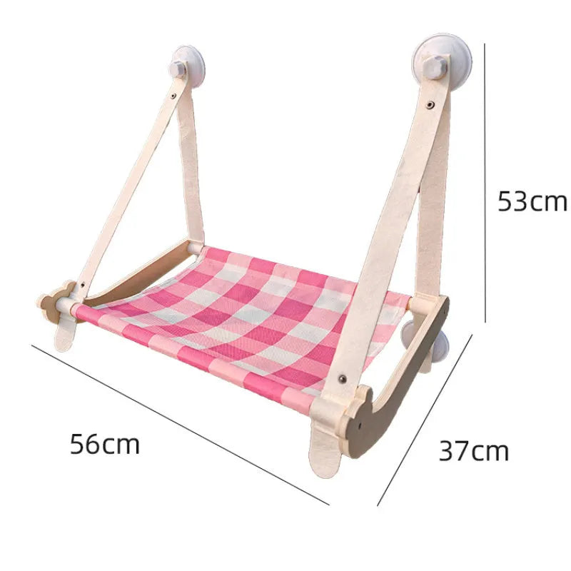 Pink foldable wooden cat window bed with suction cups attached to a glass window
