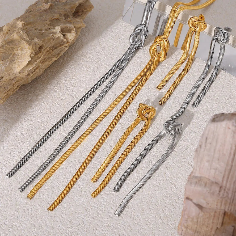 Gold knotted tassel pendant on long snake chain necklace with matching titanium steel earrings