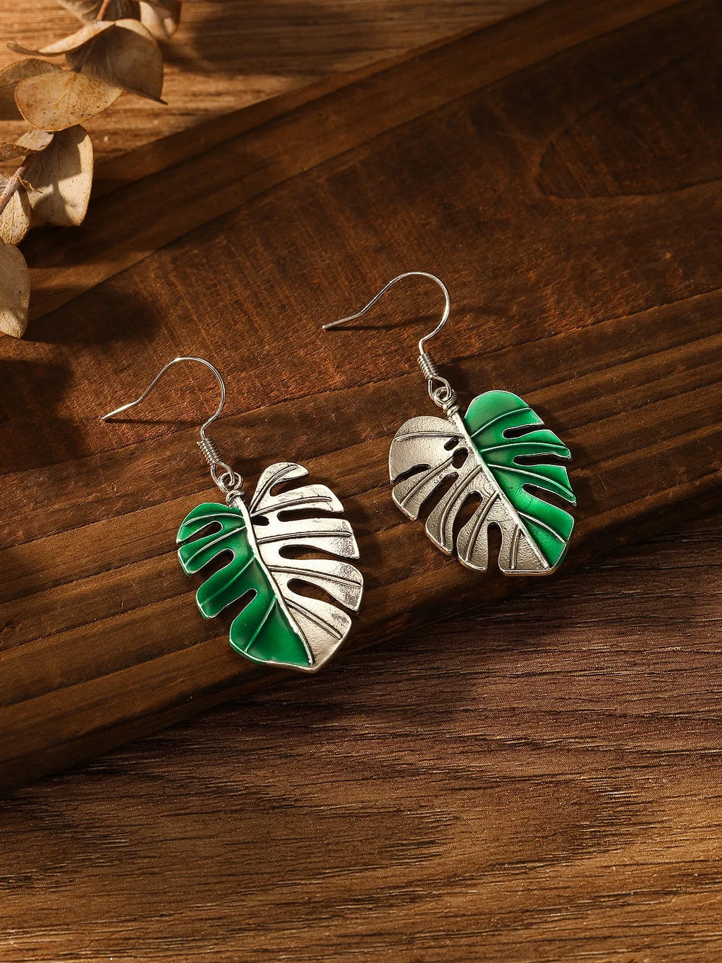 Silver alloy leaf-shaped drop earrings for women on white background