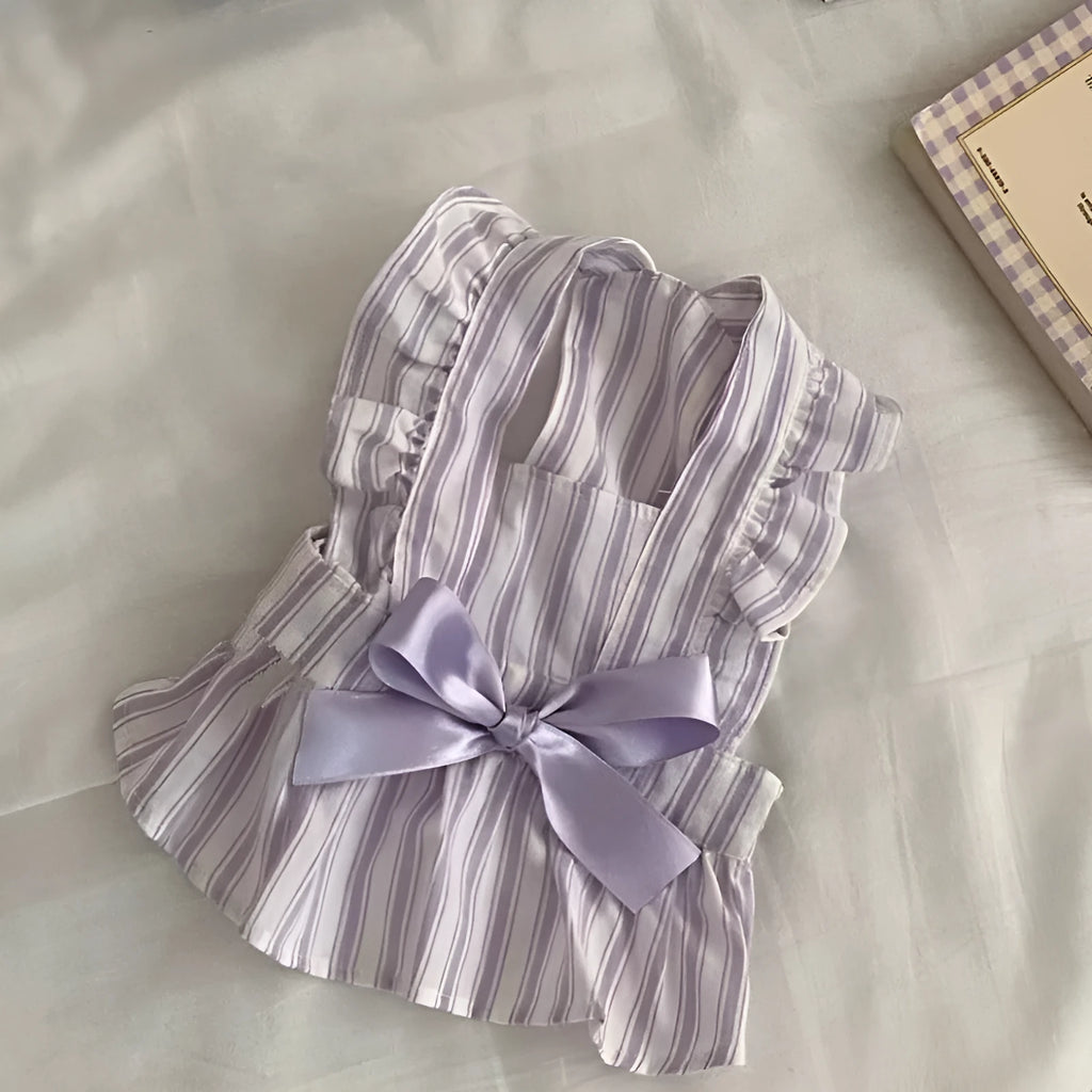 Purple dog dress with thin vest, bowknot, and striped skirt on light background
