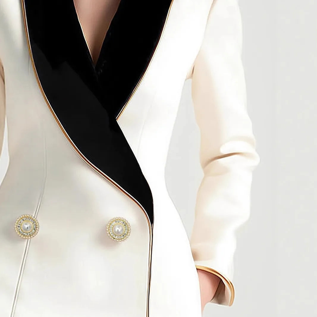 Women's milky white irregular cut long sleeve coat with golden pearl buttons on a hanger.