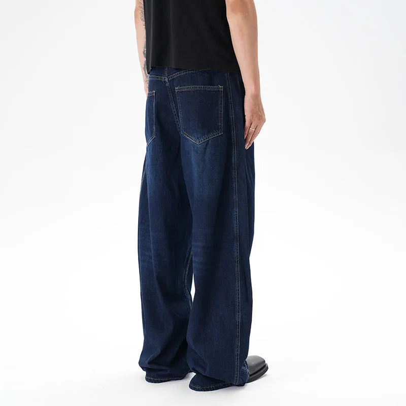 Dark blue distressed wide leg jeans with a machete cut design on a denim fabric.
