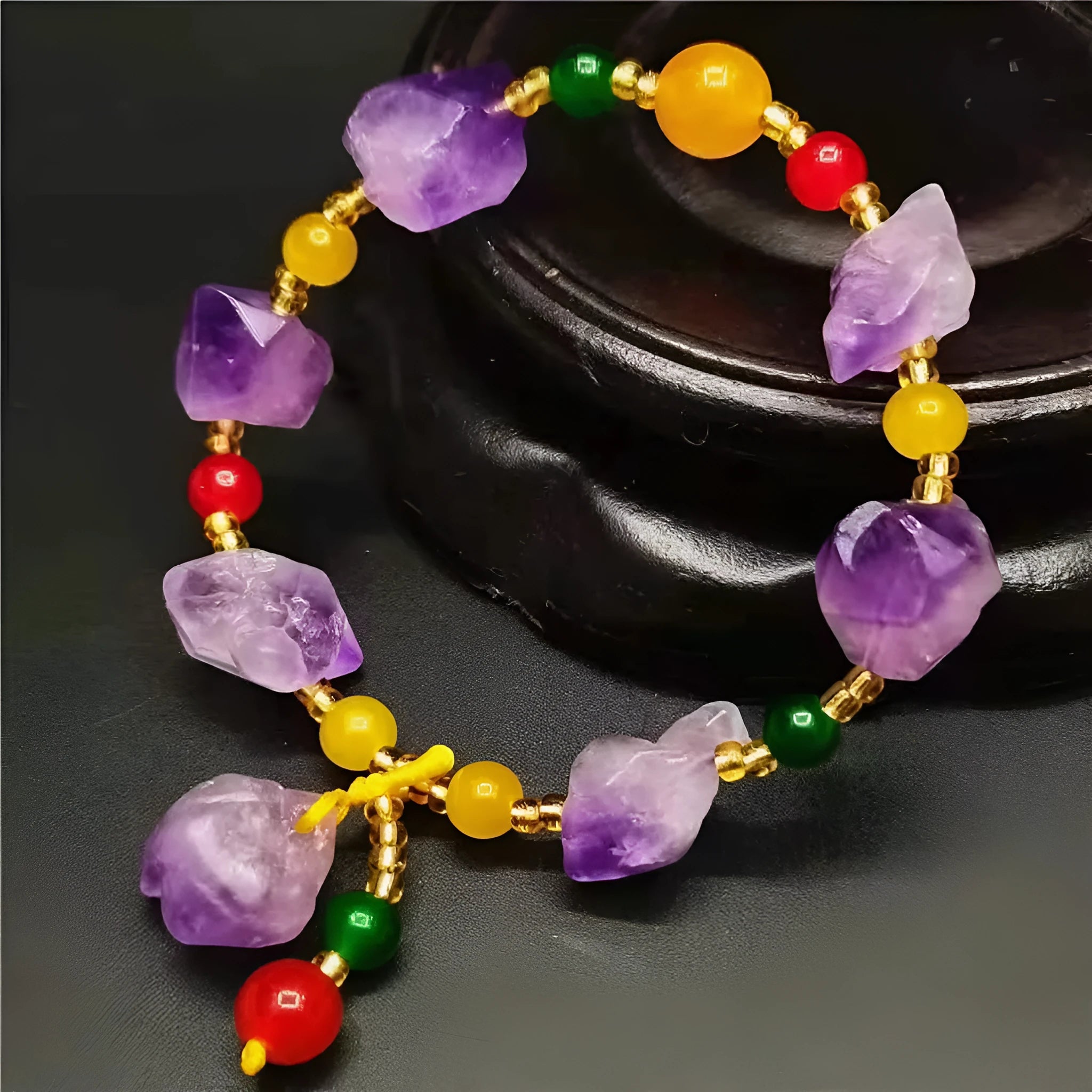 Women's natural shaped violet amethyst bead bracelet with a fu character pendant on a white background.