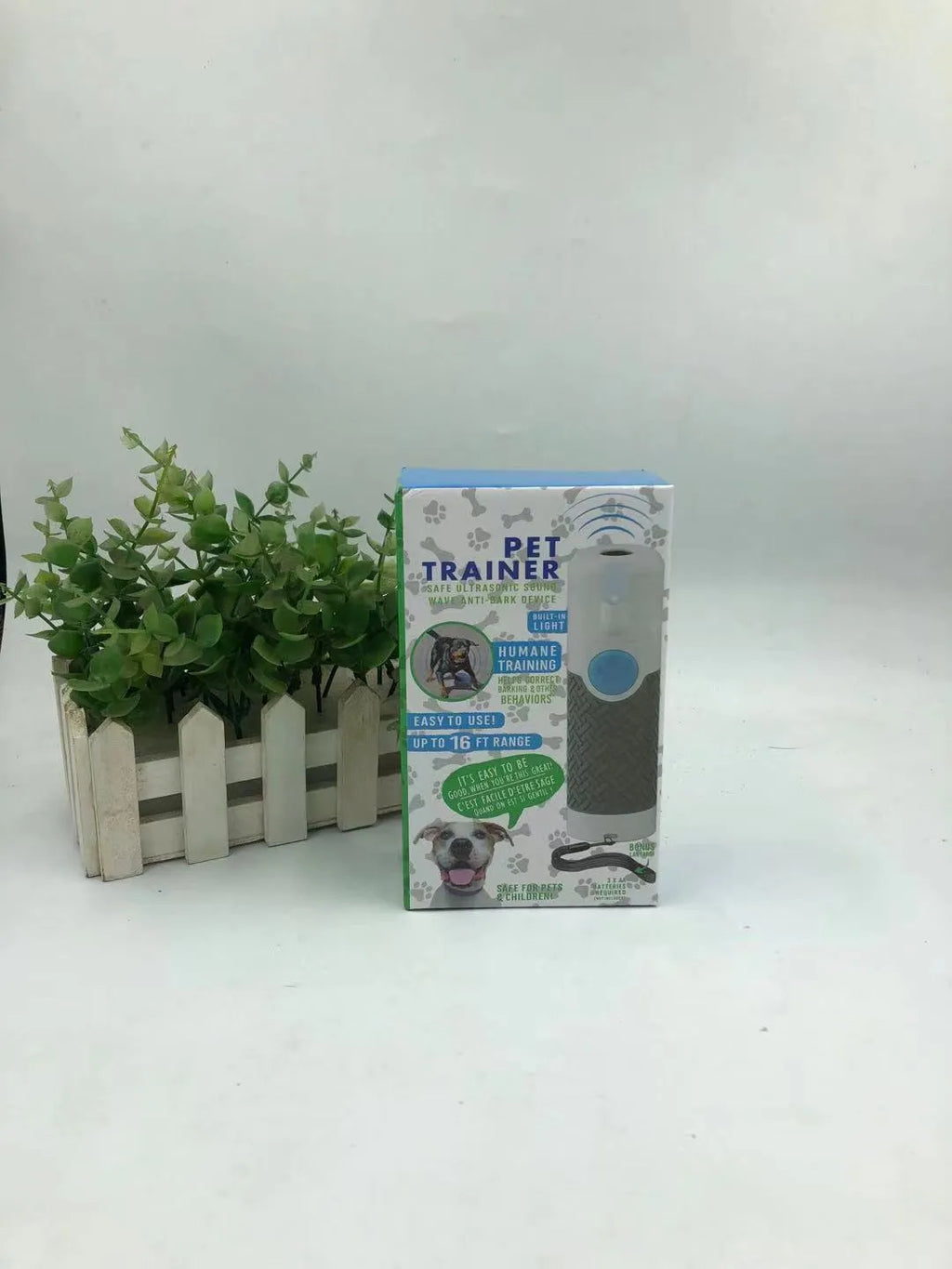 White handheld ultrasonic dog bark control trainer device on a plain background.