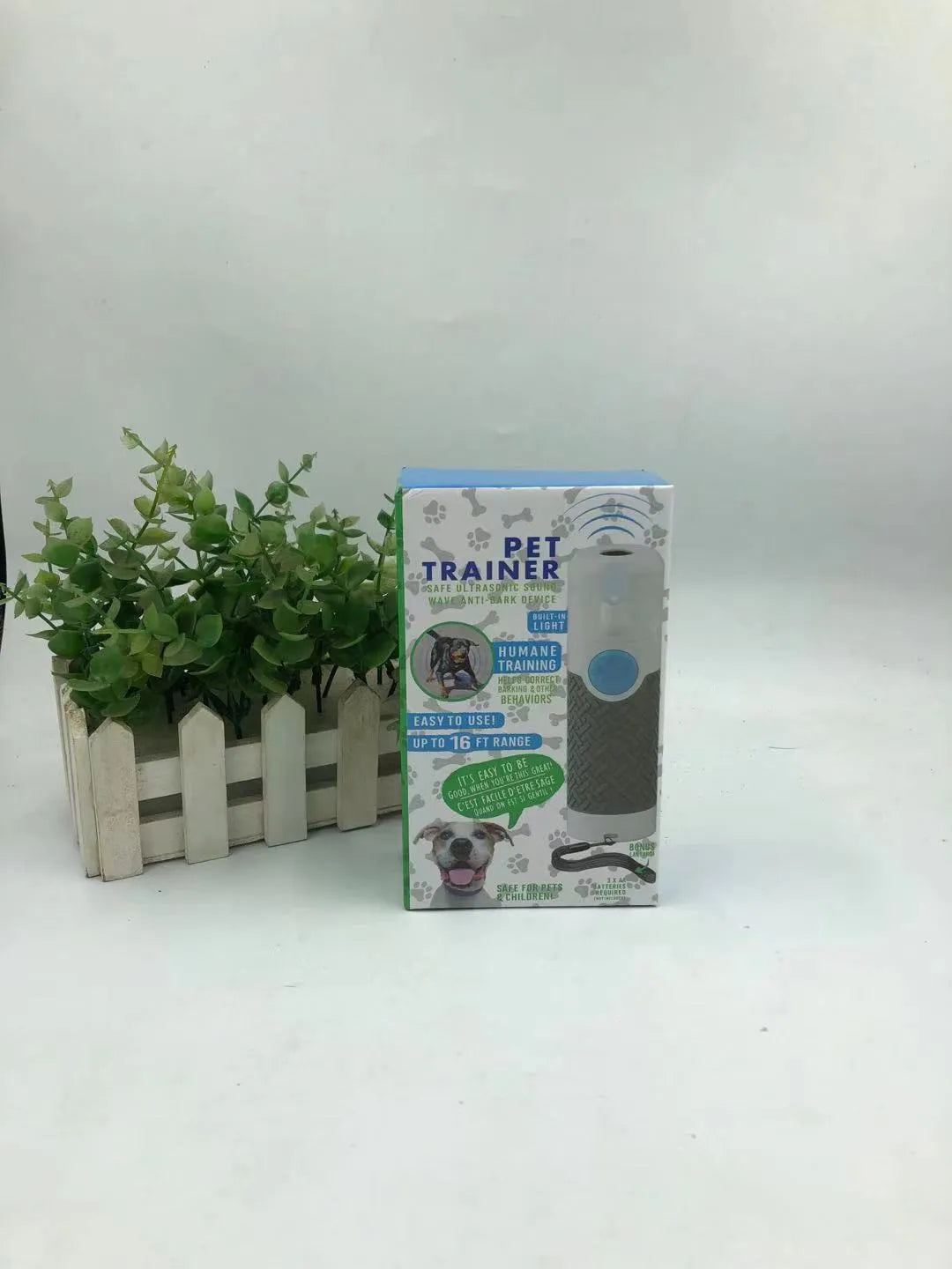 White handheld ultrasonic dog bark control trainer device on a plain background.