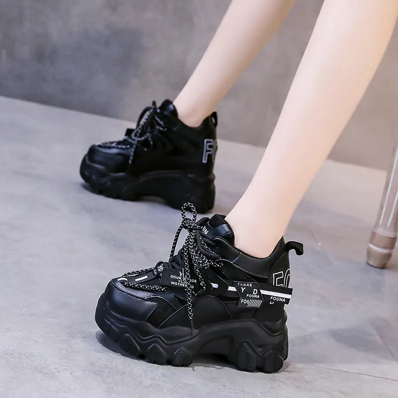 Women's white and black mesh platform sports shoes with cross strap and rubber sole.