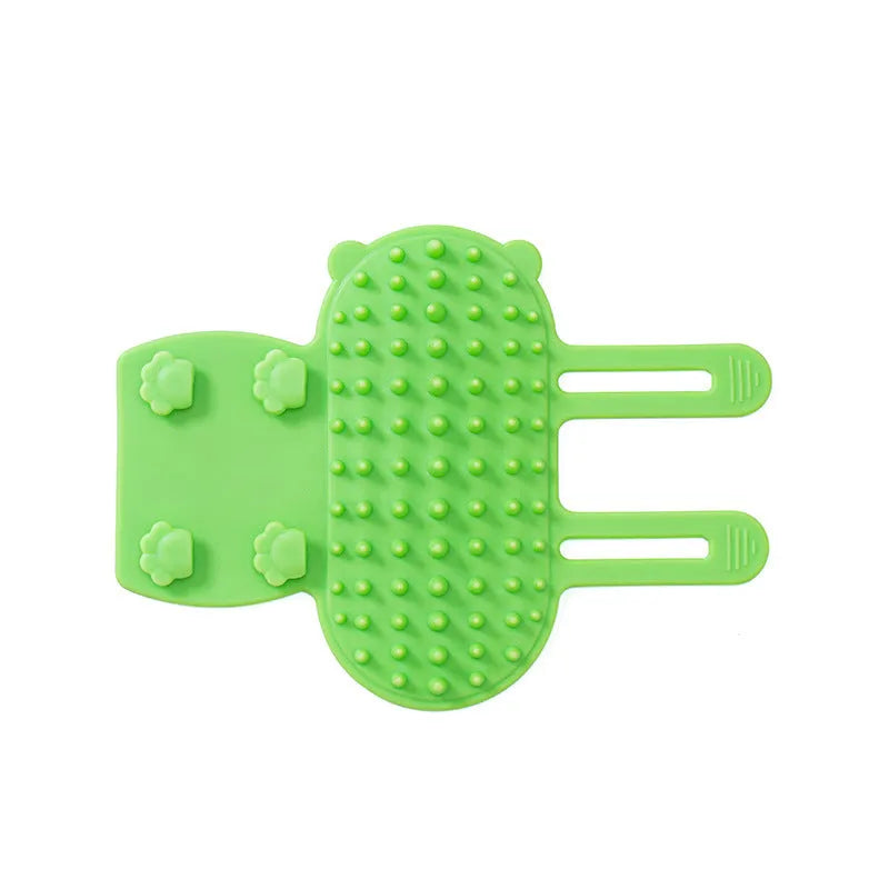 Silicone cat grooming massage comb with adjustable strap mounted on furniture leg