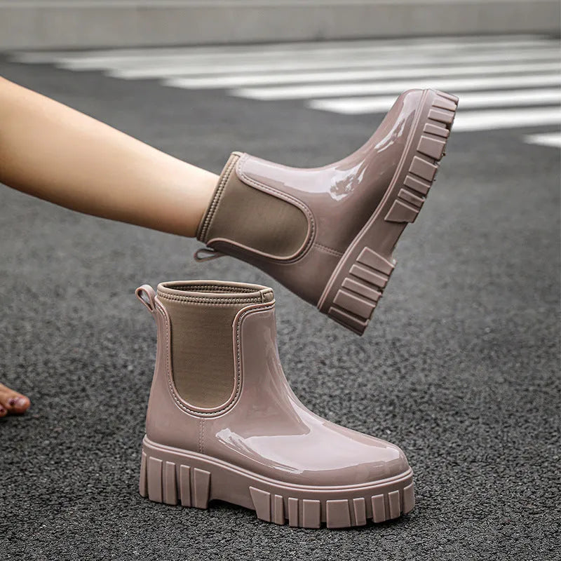 Creamy-white low tube PVC rain boot with non-slip sole on a wet surface.
