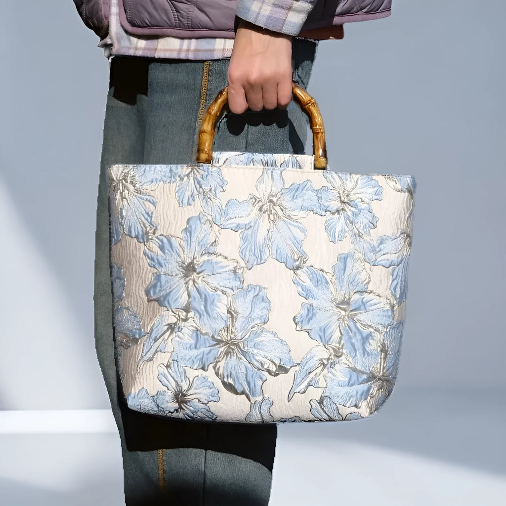 Light blue square canvas shoulder bag with bronzing flower detail and double strap connectors