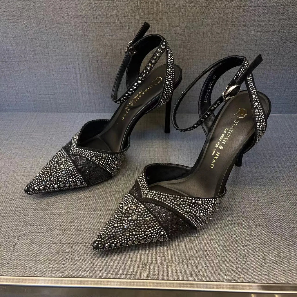 Women's black hollow high heel with stiletto heel, pointed toe, and red sole on a light background.