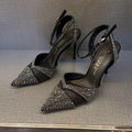 Women's black hollow high heel with stiletto heel, pointed toe, and red sole on a light background.