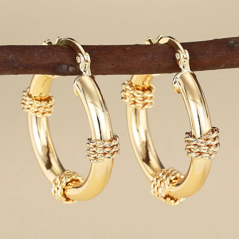 Golden geometric clip-on earrings with ring and line design elements