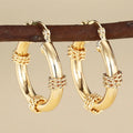 Golden geometric clip-on earrings with ring and line design elements