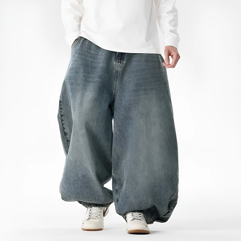 Men's plus-size baggy blue denim jeans with straight leg and low waist on a neutral background.