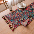 Rhyme Nordic jacquard table runner with tassel trim in a striped pattern, laid flat on a wooden table.